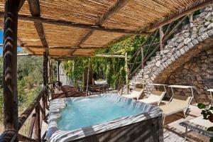 an outdoor hot tub in a building with a wooden roof at Suite Aurora in dependance in Conca dei Marini