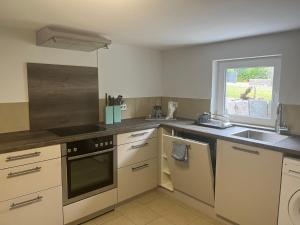 a kitchen with white cabinets and a sink and a window at Ferienwohnung Bauer in Puschendorf