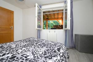 a bedroom with a black and white bed and a window at Au Fil De L'eau in Chein-Dessus