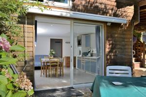 a sliding glass door leading to a patio with a table at Au Fil De L'eau in Chein-Dessus