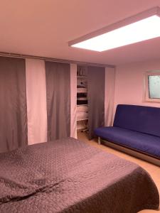 a bedroom with a bed and a blue couch at Ferienwohnung Bauer in Puschendorf