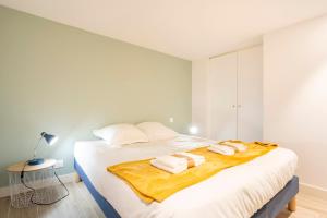 a bedroom with a large bed with towels on it at Le Pied-à-terre in Bénodet