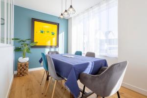 a dining room with a blue table and chairs at Le Pied-à-terre in Bénodet