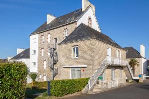 a large brick building with a staircase in front of it at Le Pied-à-terre in Bénodet