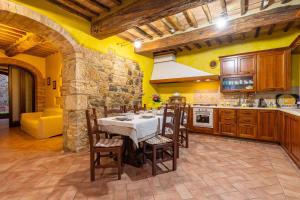 a kitchen with a table and chairs in a room at Podere Spagliarda in San Quirico dʼOrcia