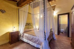 a bedroom with a canopy bed and a bathroom at Podere Spagliarda in San Quirico dʼOrcia +23 photos
