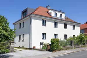 a white building with a red roof at Ferienwohnung Skyline Suite in Bayreuth