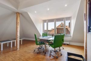 a dining room with a table and green chairs at Ferienwohnung Skyline Suite in Bayreuth