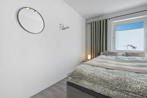 a bedroom with a bed and a mirror on the wall at Ferienwohnung aufm Weinberg in Schwandorf in Bayern