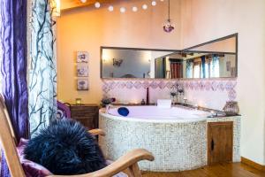 a bathroom with a tub and a dog sitting in a chair at La Tarabilla in Casas del Abad +15 photos