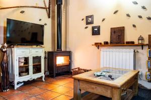 a living room with a tv and a fireplace at La Tarabilla in Casas del Abad