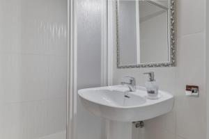 a white bathroom with a sink and a mirror at Apartamento en Vejer in Vejer de la Frontera +15 photos