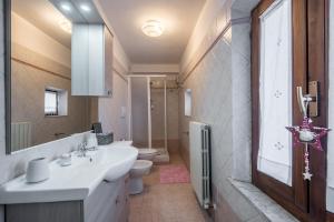a bathroom with a sink and a toilet and a window at Casa Al Colle Buonconvento in Buonconvento