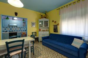 a living room with a blue couch and a kitchen at Paolo e Francesca in Bosa Marina