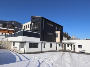 a black and white building with snow on the ground at Steinwender in Kaltenbach