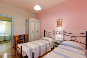 two beds in a room with pink walls at Paolo e Francesca in Bosa Marina