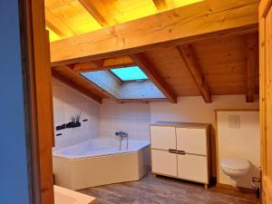 a bathroom with a bath tub and a toilet at Le Refuge - Faucigny in Faucigny