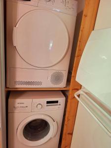 a washer and dryer in a kitchen with a refrigerator at Le Refuge - Faucigny in Faucigny