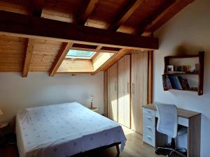 a bedroom with a bed and a desk and a window at Le Refuge - Faucigny in Faucigny