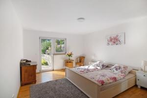 a white bedroom with a bed and a window at Fewo Landschaftstraum am Bodensee in Lindau