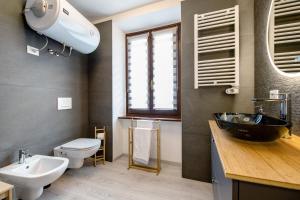 a bathroom with a black sink and a toilet at Le Lavande in Castro +20 photos