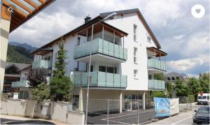 a white building with blue balconies on it at Stadtdomizil TOP 10 in Schladming
