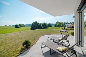a patio with two chairs and a table on a porch at Fewo Landschaftstraum am Bodensee in Lindau
