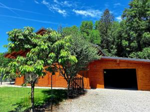 a brick building with a garage and two trees at Le Refuge - Faucigny in Faucigny