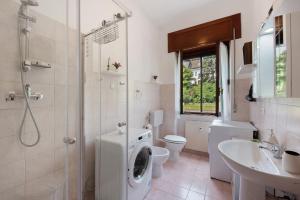 a bathroom with a toilet a sink and a washing machine at La Casa Della Gioia - Serravalle in Serravalle Scrivia +18 photos