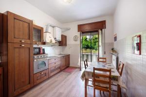 a kitchen with wooden cabinets and a table in it at La Casa Della Gioia - Serravalle in Serravalle Scrivia