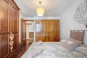 a living room with a bed and a wooden cabinet at Appartamento Delfine in La Salle