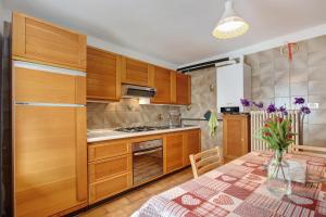 a kitchen with wooden cabinets and a table in a room at Appartamento Delfine in La Salle