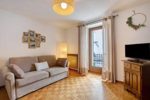 a living room with a couch and a flat screen tv at Appartamento Delfine in La Salle