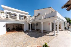 a large white house with a large patio at Holiday Villa Torrenueva in La Cala de Mijas