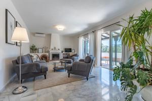 a living room with couches and chairs and a fireplace at Holiday Villa Torrenueva in La Cala de Mijas