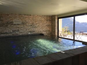 a swimming pool in a room with a brick wall at Italian Heaven in Perledo