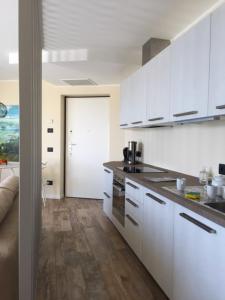 a kitchen with white cabinets and wooden floors at Italian Heaven in Perledo