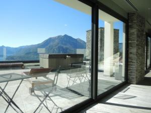 a balcony with a table and chairs and mountains at Italian Heaven in Perledo