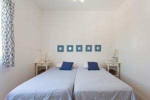 two beds in a white room with blue pillows at Villa Jodie in Sóller +17 photos