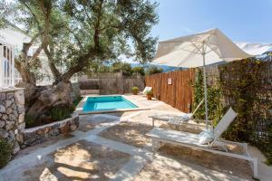 a backyard with a pool and an umbrella and a bench at Villa Jodie in Sóller