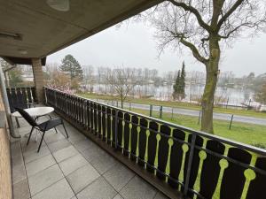ein Balkon mit Tisch, Stuhl und einem Baum in der Unterkunft Seeblick in Versmold