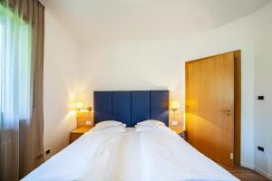 a bedroom with a large bed with a blue headboard at Gartenheim App Martin in Schenna