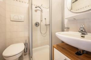 a bathroom with a sink and a toilet and a shower at Manuel's App Watschinger Alpenrose in Sesto +13 photos