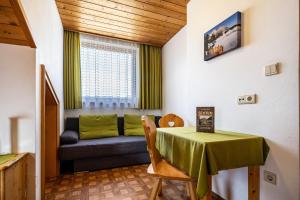 a living room with a table and a couch at Manuel's App Watschinger Alpenrose in Sesto