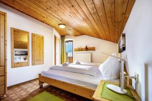 a bedroom with a bed with a wooden ceiling at Manuel's App Watschinger Alpenrose in Sesto