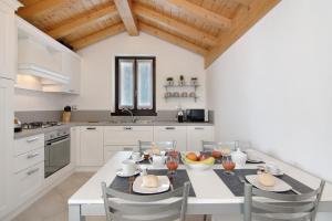 a kitchen with a white table and chairs in a kitchen at Borgo Vico in Verceia