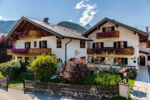 a house in the mountains with flowers on the balconies at Ferienhaus St Christoph in Mittenwald