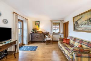 a living room with a couch and a tv at Landhaus Kauderer - Wohnung 2 in Waging am See