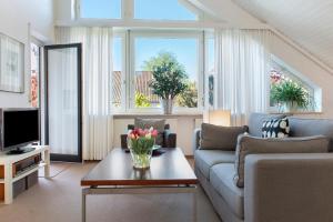 a living room with a couch and a tv at Ferienwohnungen Riedel in Immenstaad am Bodensee