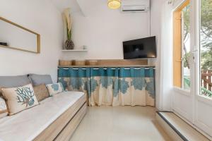 a living room with a couch and a tv at Appartement Pinède in Cap d'Agde